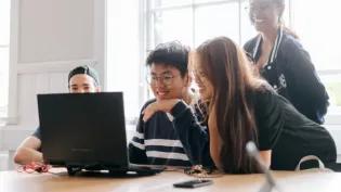 students learning together around a laptop
