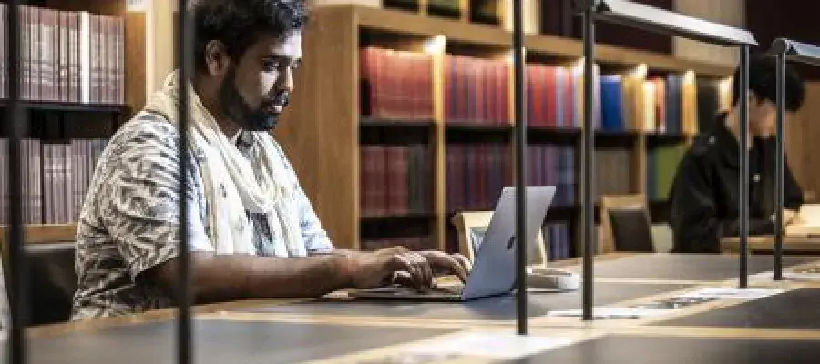 Researcher with laptop in Law library