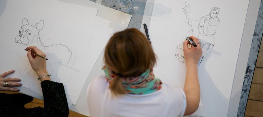 Students take part in the 'Best in Show' drawing event in the ECA Main Building, drawing dogs with their owners.