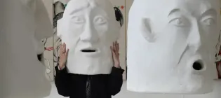 ECA student Elena Gadd wears a large white 'head' sculpture created as part her final showcase 'The Funeral'.
