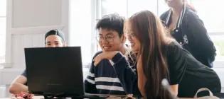 students learning together around a laptop