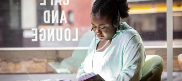 Student with book in cafe