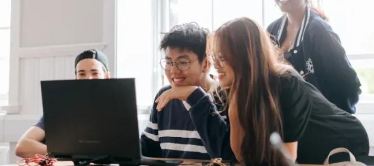 students learning together around a laptop