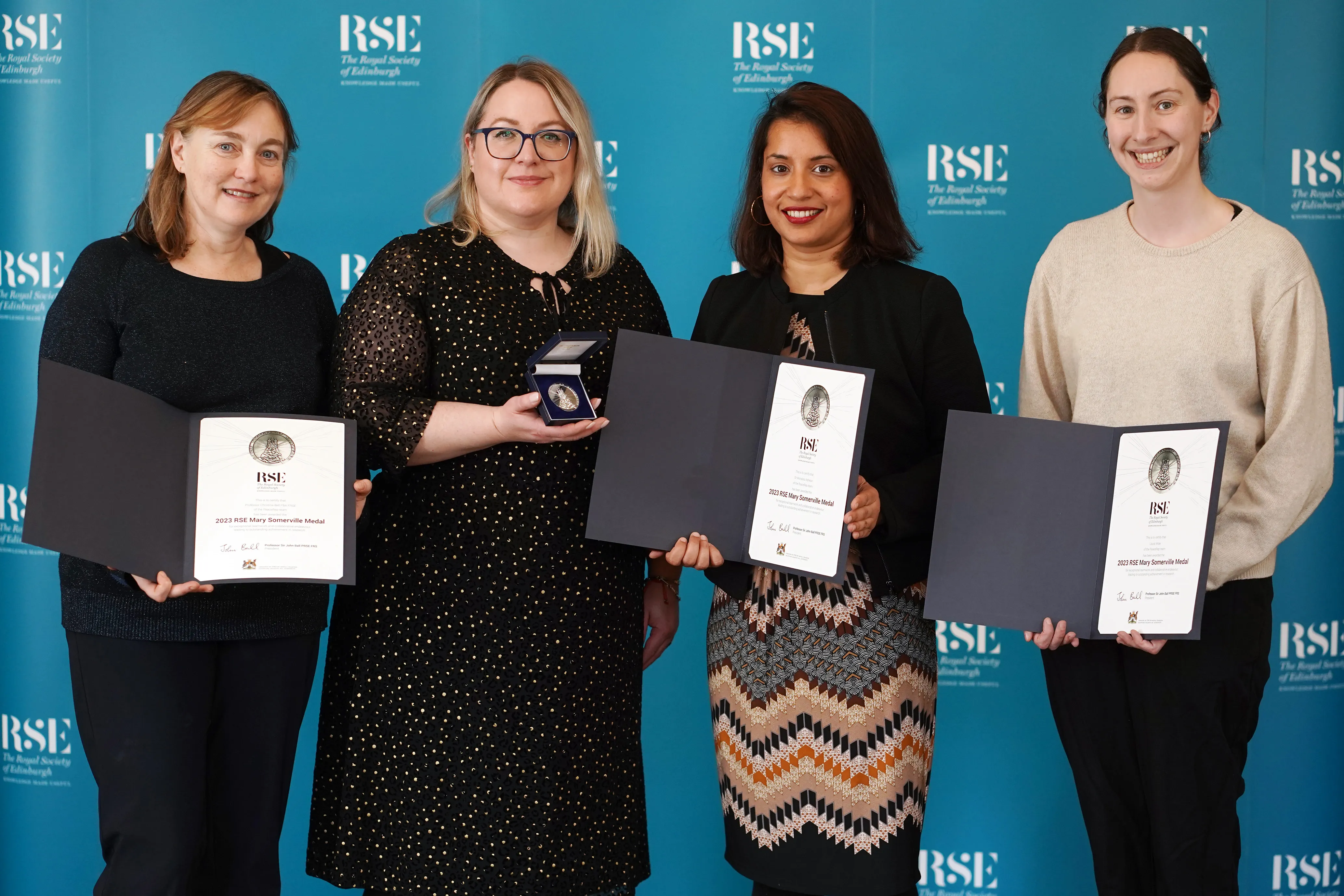 Four academics with certificates