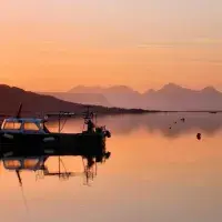 Boat in lake in front of sunrise