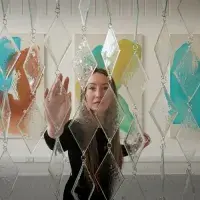Sculpture student Kristel Bodensiek approaches her work Tide and Temper, a calming curtain made of glass and steel.