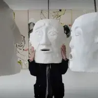 ECA student Elena Gadd wears a large white 'head' sculpture created as part her final showcase 'The Funeral'.