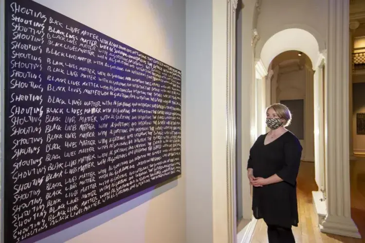 Larry Achiampong. Detention.  Blackboard, chalk. Pictured – Melissa MacRobert, Exhibitions Manager at Talbot Rice Gallery