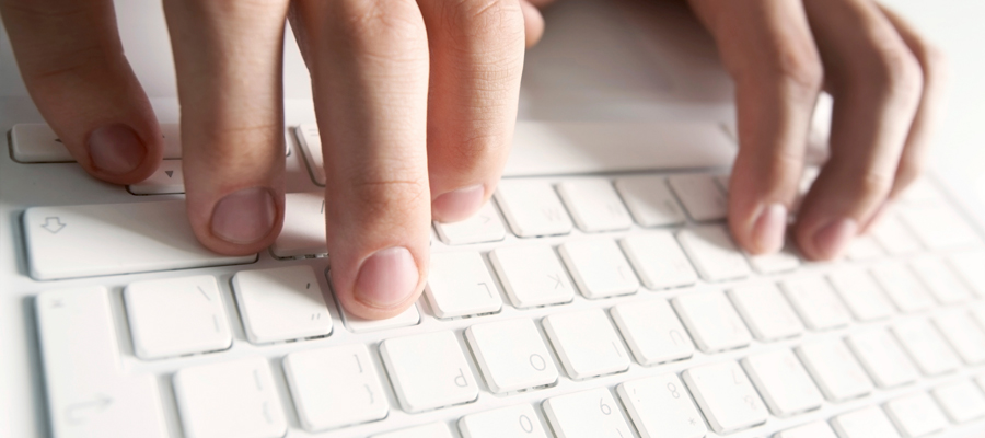 fingers typing on white keyboard