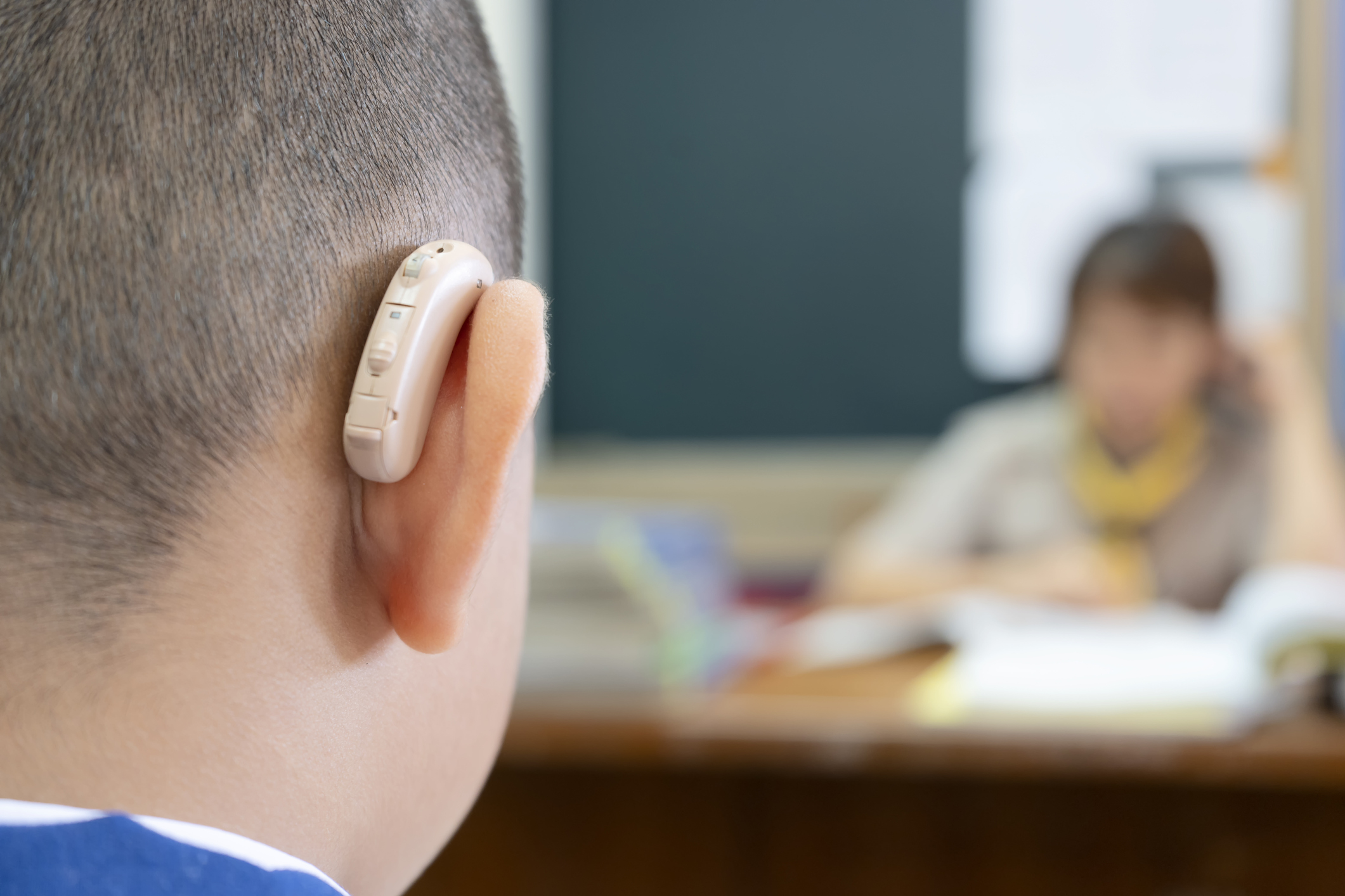 Student with hearing listening to teacher in class.